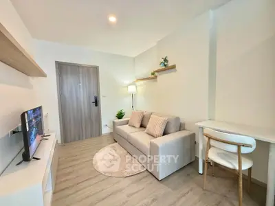Modern living room with cozy sofa, TV, and stylish decor in a bright apartment.