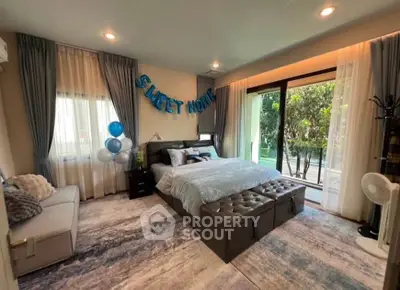 Luxurious bedroom with elegant decor and garden view, featuring cozy seating and stylish lighting.