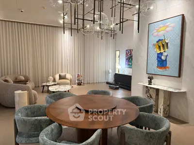 Luxurious modern living room with elegant chandelier and stylish art pieces, perfect for sophisticated gatherings.