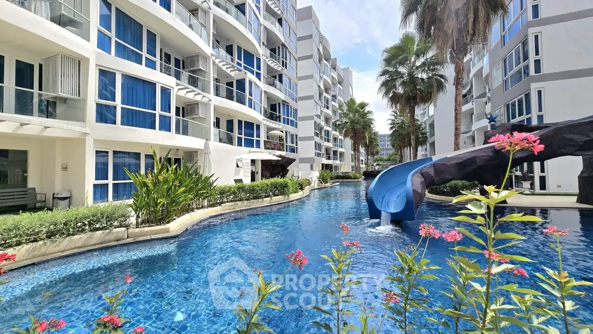 Luxurious condo with stunning pool and slide, surrounded by lush greenery and modern architecture.