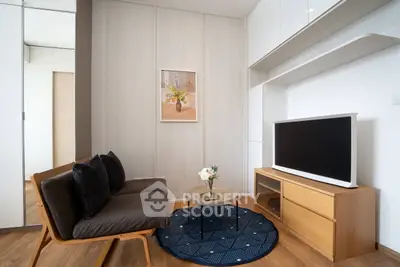 Modern living room with sleek furniture and wall-mounted TV in a stylish apartment.