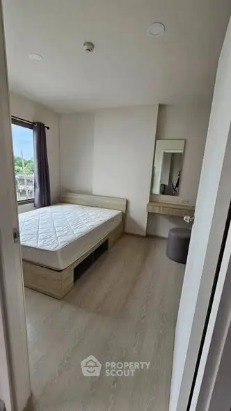 Spacious bedroom with natural light and modern furnishings in a stylish apartment.