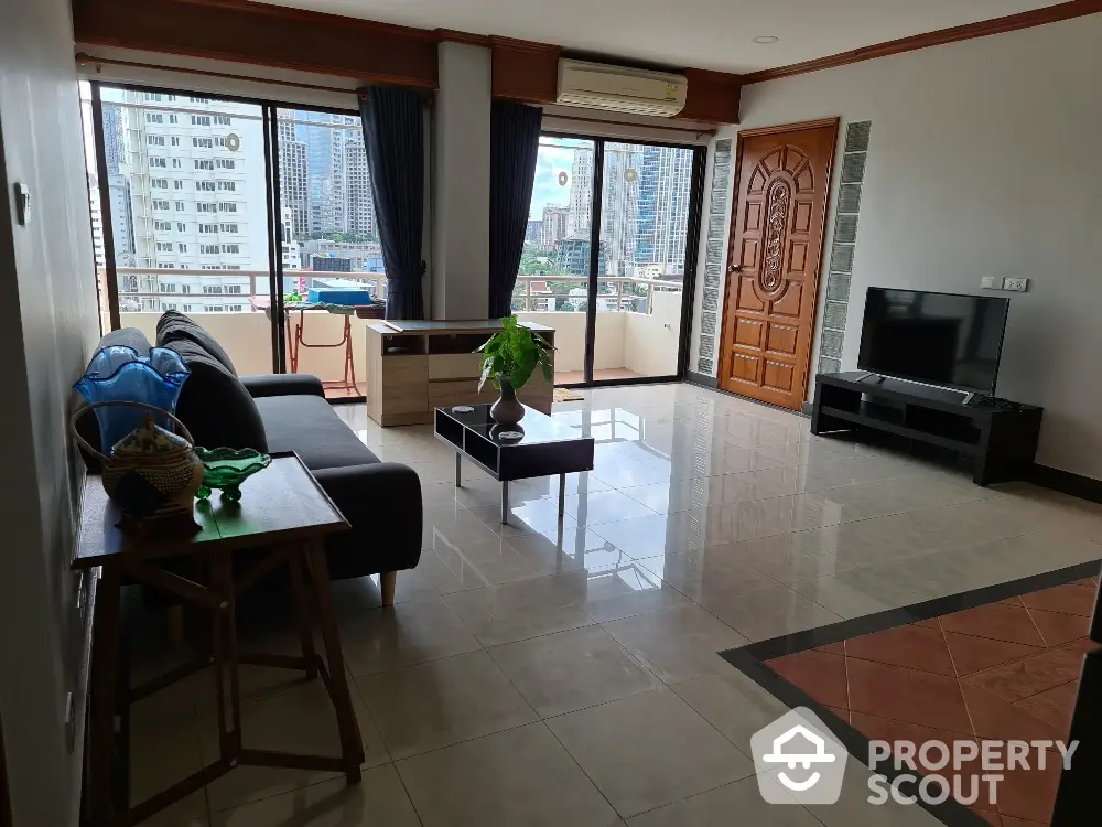 Spacious living room with city view, modern furniture, and large windows in urban apartment.