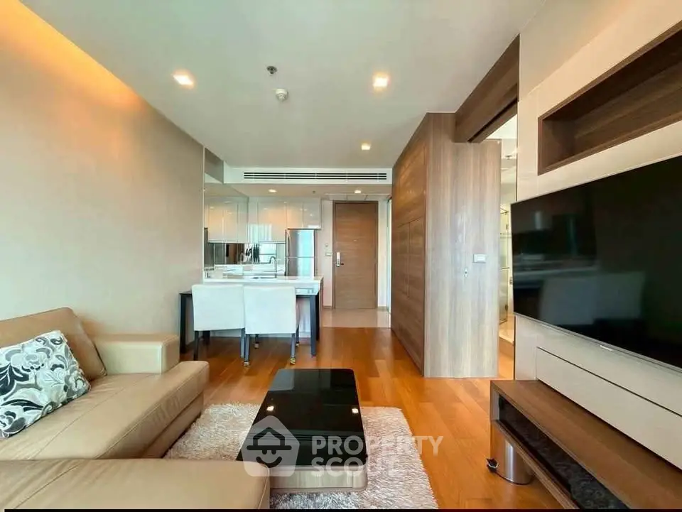 Modern living room with sleek furniture and open kitchen layout in a stylish apartment.