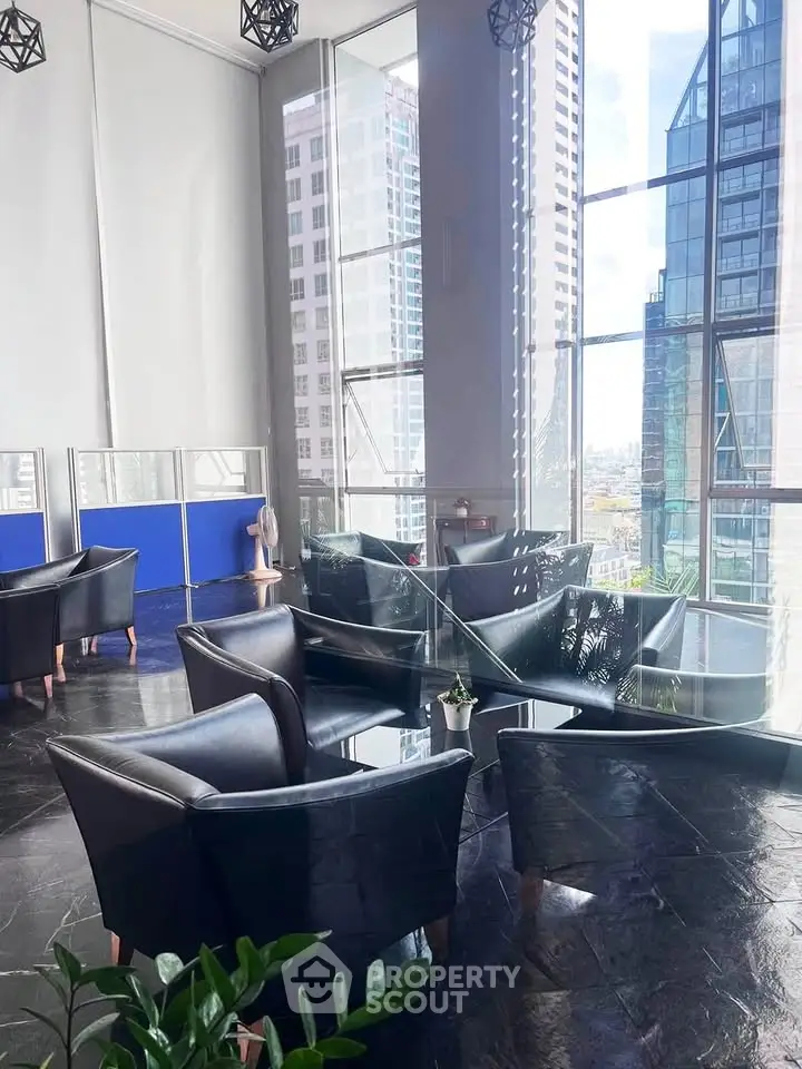 Modern office lounge with city view and sleek black leather chairs