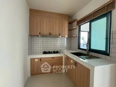 Modern kitchen with wooden cabinets and gas stove in a bright apartment