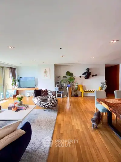 Spacious modern living room with wooden flooring and stylish decor in a luxury apartment.