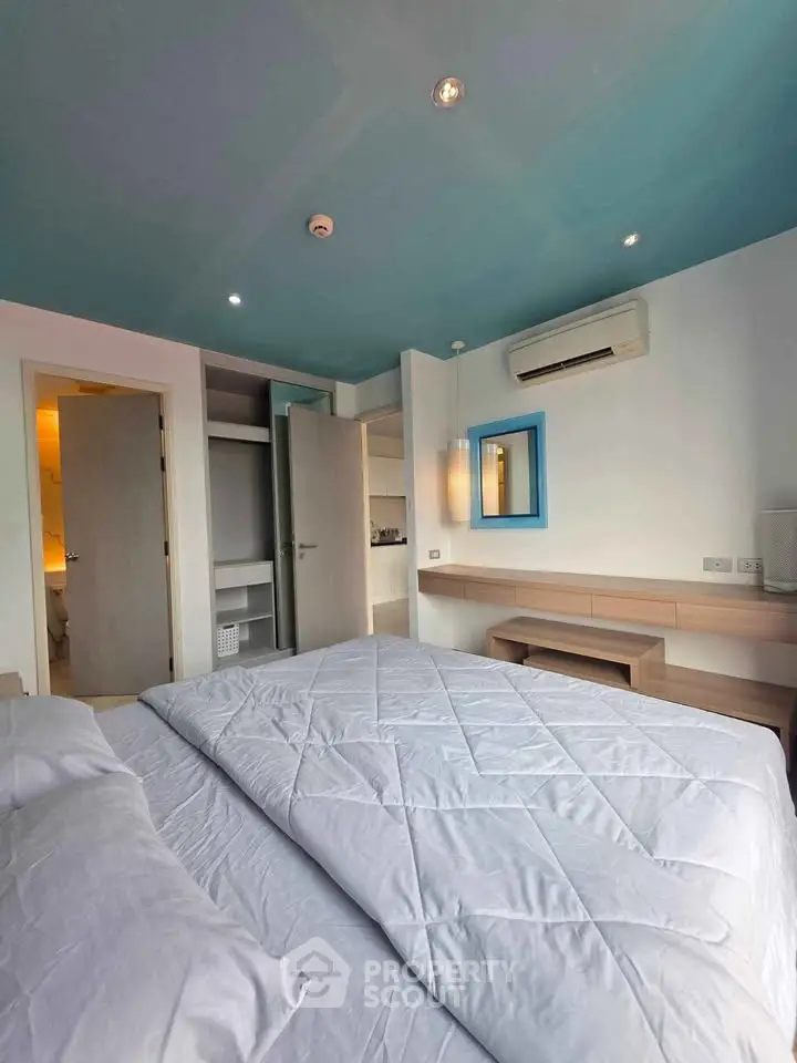 Modern bedroom with stylish decor and ample natural light, featuring a cozy bed and built-in storage.