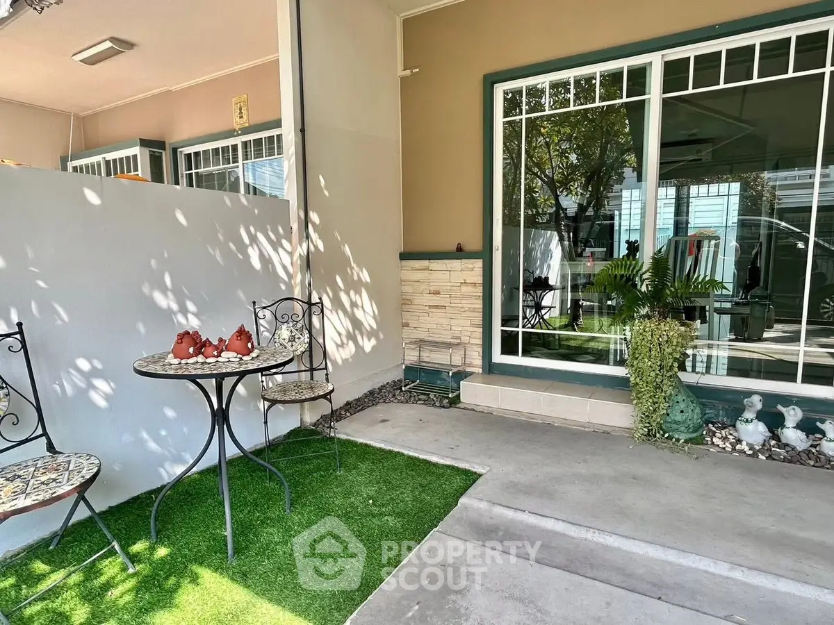 Charming patio with outdoor seating and lush greenery, perfect for relaxation.