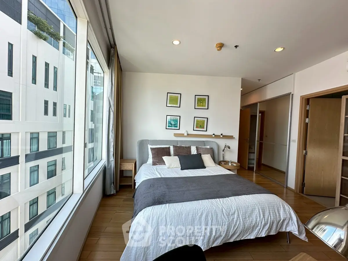 Modern bedroom with large windows and stylish decor in a high-rise apartment