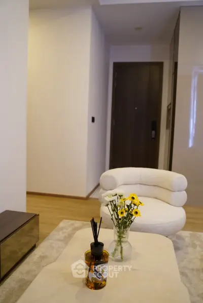 Modern living room with stylish chair and floral decor, showcasing elegant interior design.