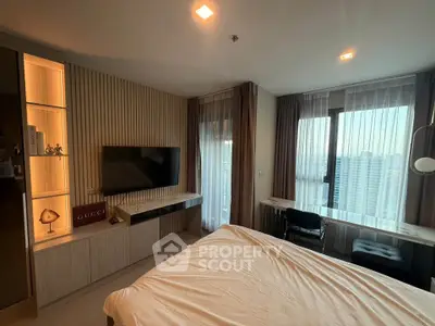 Modern bedroom with stylish decor and city view, featuring a wall-mounted TV and elegant furnishings.