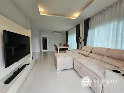 Spacious modern living room with large sectional sofa and sleek entertainment setup