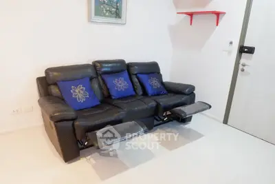 Modern living room with black leather recliner sofa and decorative pillows