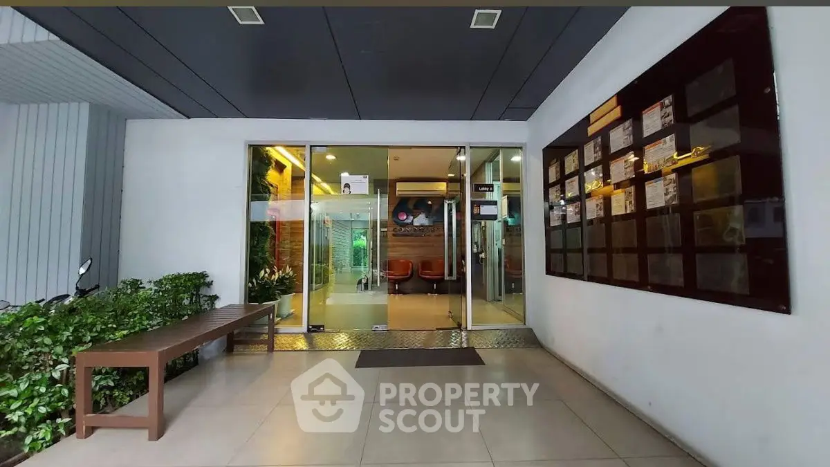 Modern building entrance with glass doors and seating area