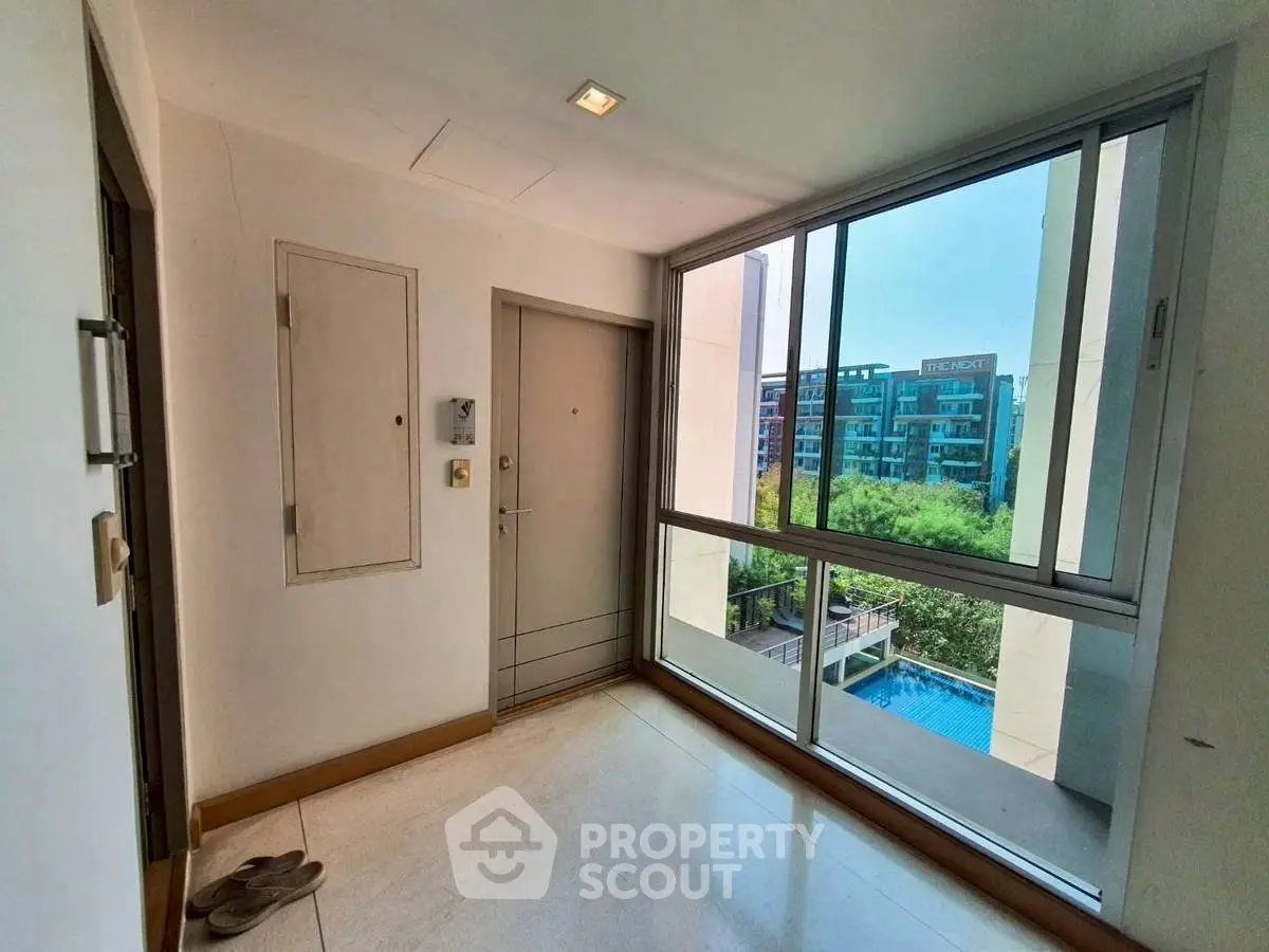 Modern apartment entrance with large window and pool view