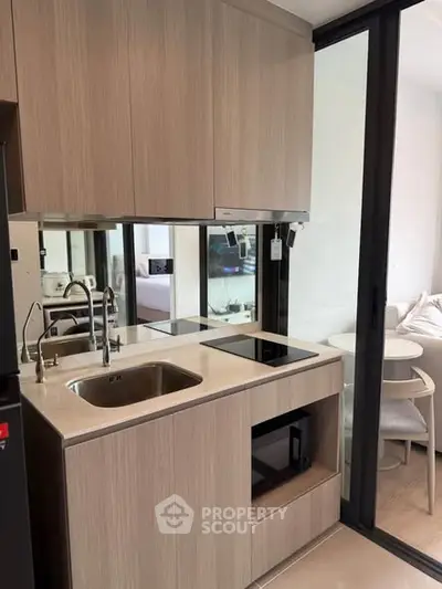 Modern compact kitchen with sleek cabinetry and integrated appliances in a stylish apartment.