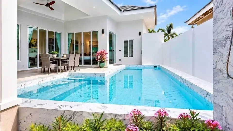 Luxurious modern villa with private pool and elegant outdoor dining area.