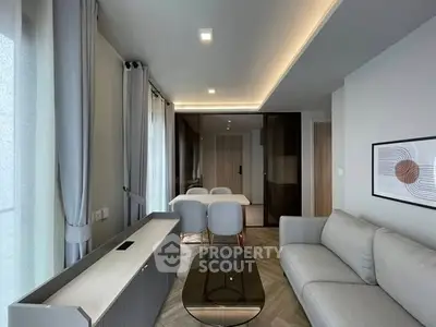 Modern living room with sleek furniture and elegant dining area, featuring contemporary design and ample natural light.