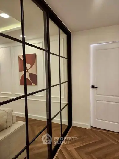 Modern interior with glass partition and stylish artwork in cozy living space.