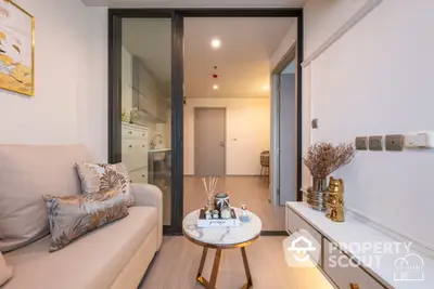 Cozy modern living room with elegant furnishings, neutral color palette, and a seamless transition to a well-lit kitchen area, perfect for urban living.