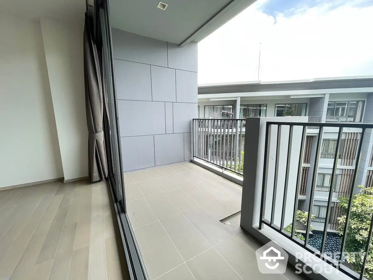 Spacious balcony with modern tiles and a serene view, perfect for outdoor relaxation and entertaining in a contemporary residence.