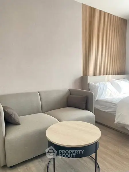 Modern bedroom with cozy sofa and stylish wooden accent wall