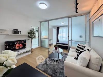 Modern living room with cozy sofa and stylish decor in open-plan apartment.