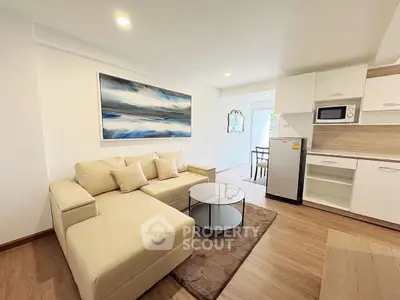 Modern living room with beige sofa, stylish kitchen, and elegant decor