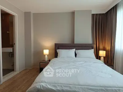 Modern bedroom with cozy lighting and ensuite bathroom in a stylish apartment.