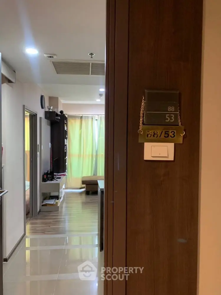 Inviting modern apartment interior showcasing a sleek hallway leading to a cozy living space with ample natural light and contemporary furnishings.