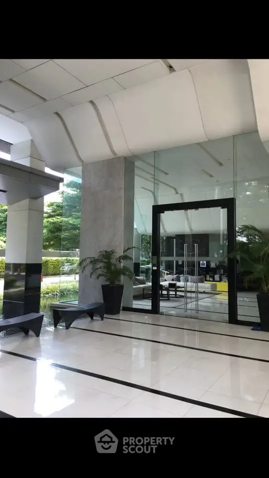 Elegant building entrance with modern glass doors and stylish seating area.