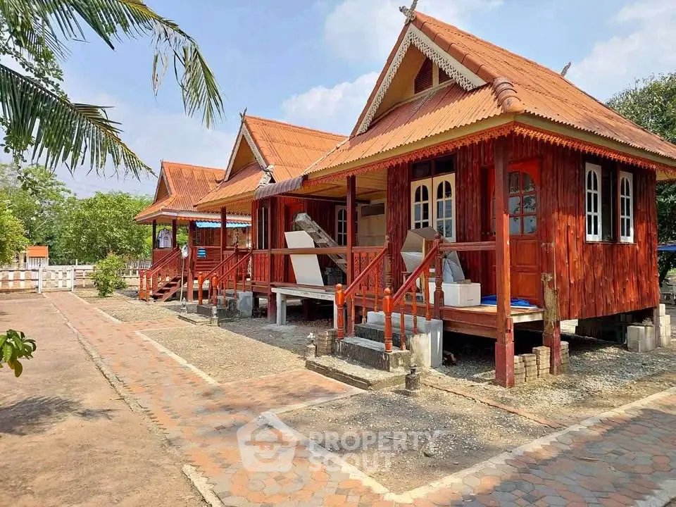Charming rustic wooden cabins with red roofs and inviting porches in a serene setting.