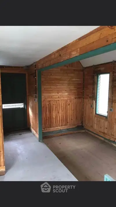 Charming rustic interior with wooden walls and natural light, perfect for cozy living.