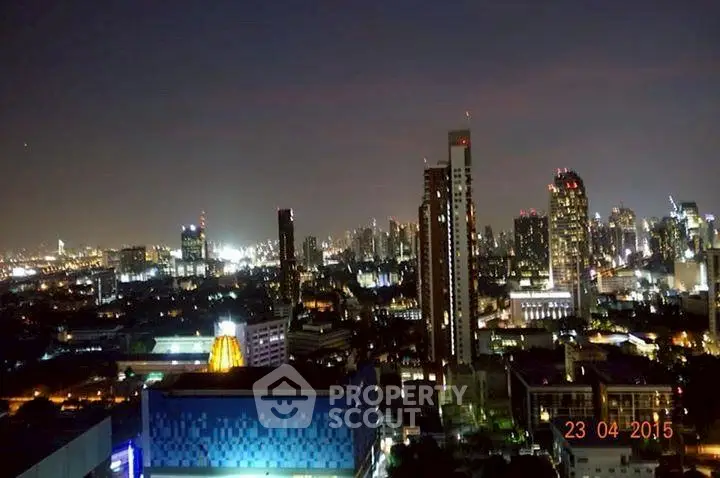 Stunning city skyline view from a high-rise building at night, showcasing vibrant urban lights.