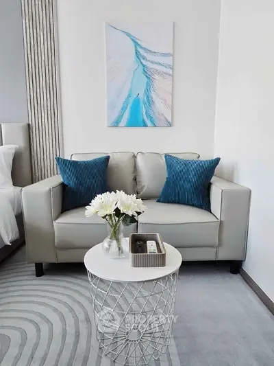 Modern living room with stylish sofa, blue cushions, and elegant decor