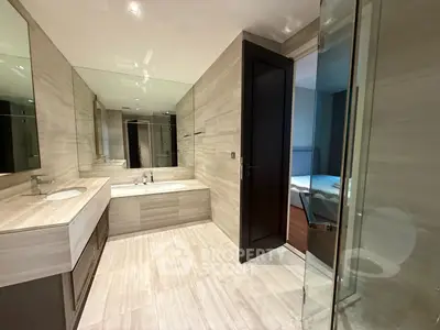 Luxurious modern bathroom with sleek design and spacious layout, featuring a bathtub and elegant fixtures.