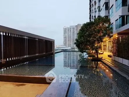 Luxurious apartment building with serene pool and modern architecture.