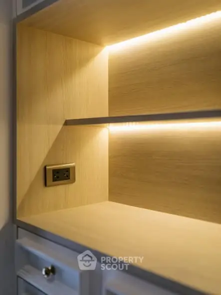 Modern wooden shelving unit with built-in lighting and power outlet