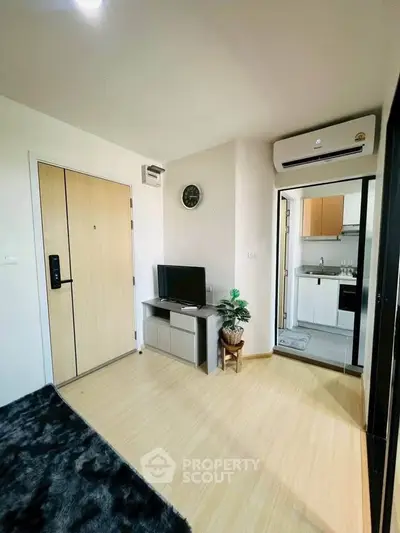 Modern living room with sleek TV setup and open kitchen view