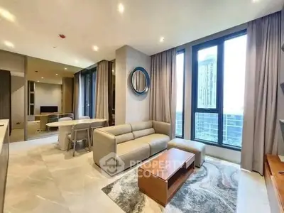 Modern living room with large windows and stylish furniture in a high-rise apartment.