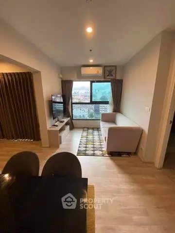 Modern living room with city view, cozy seating, and stylish decor.