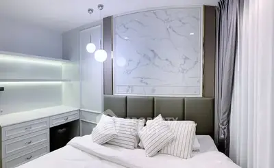 Luxurious modern bedroom with elegant marble accent wall and stylish lighting.