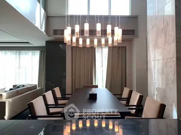 Luxurious dining area with elegant chandelier and modern decor in a spacious living room.