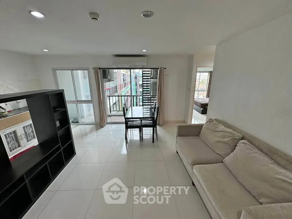 Spacious living room with modern decor and balcony access in urban apartment.