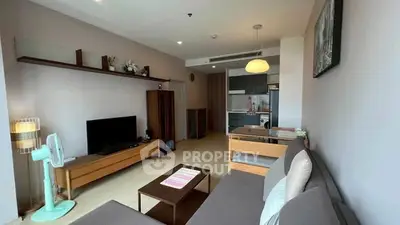 Spacious modern living room with open kitchen and stylish decor in a cozy apartment.