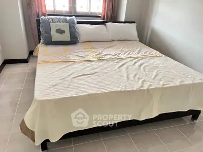 Cozy bedroom with large bed and natural light from window, perfect for relaxation.
