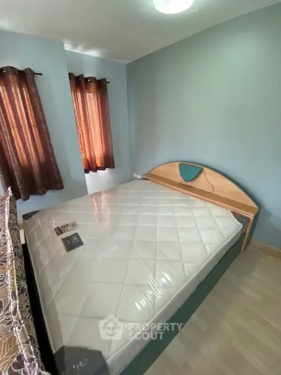 Cozy bedroom with a modern bed and natural light through elegant curtains.