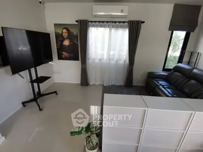 Modern living room with sleek leather sofa and large TV, featuring elegant curtains and minimalist decor.