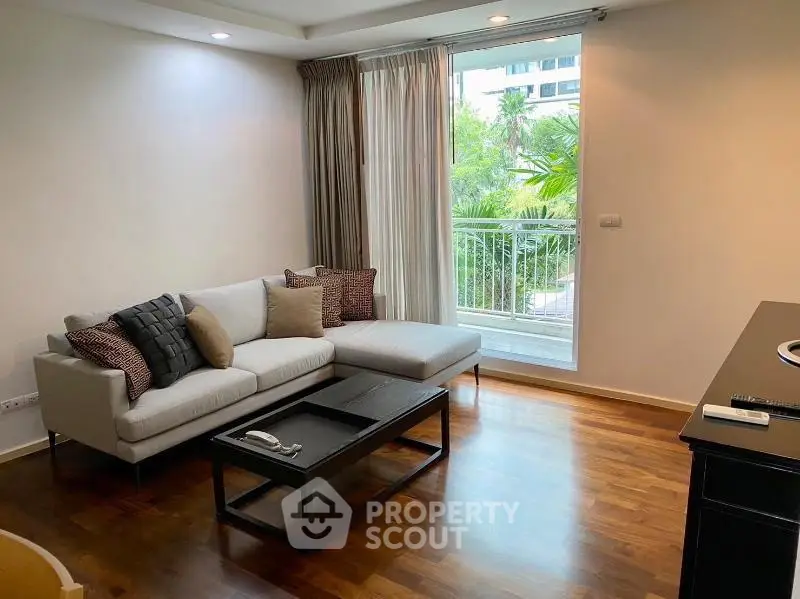 Modern living room with cozy sofa and large window overlooking greenery, perfect for relaxation.
